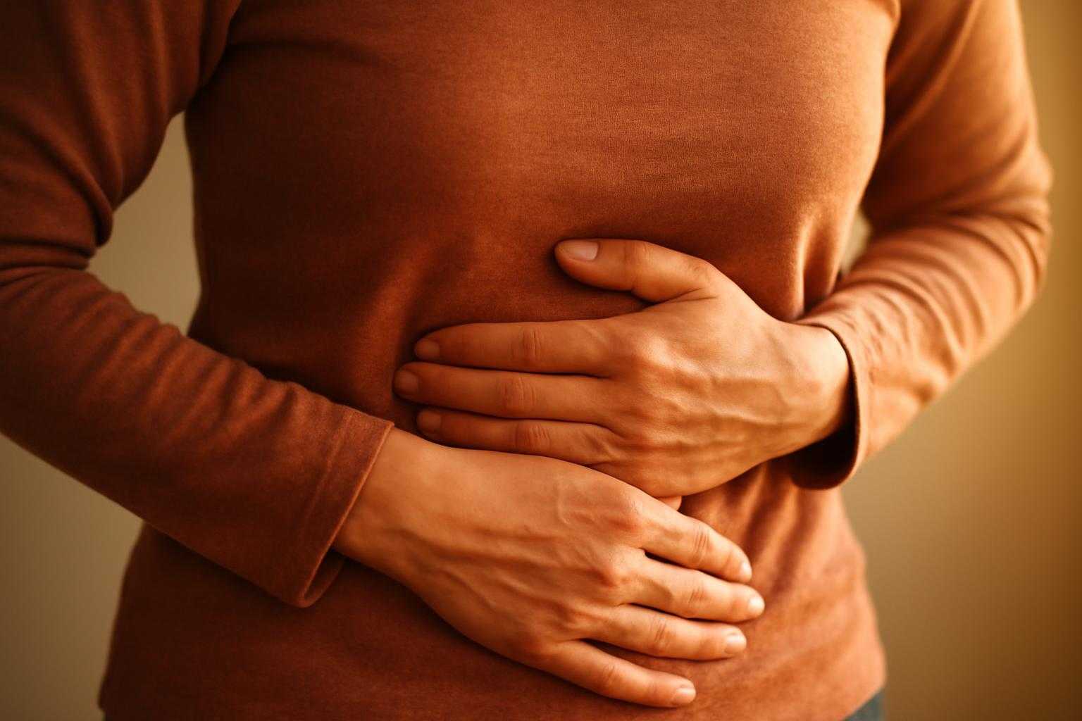 お腹の痛みで苦しむ人の腹部を抑える様子